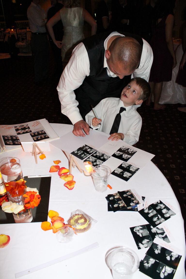 little boy looking at his dad for advice for writing in chicago memory booths memory book